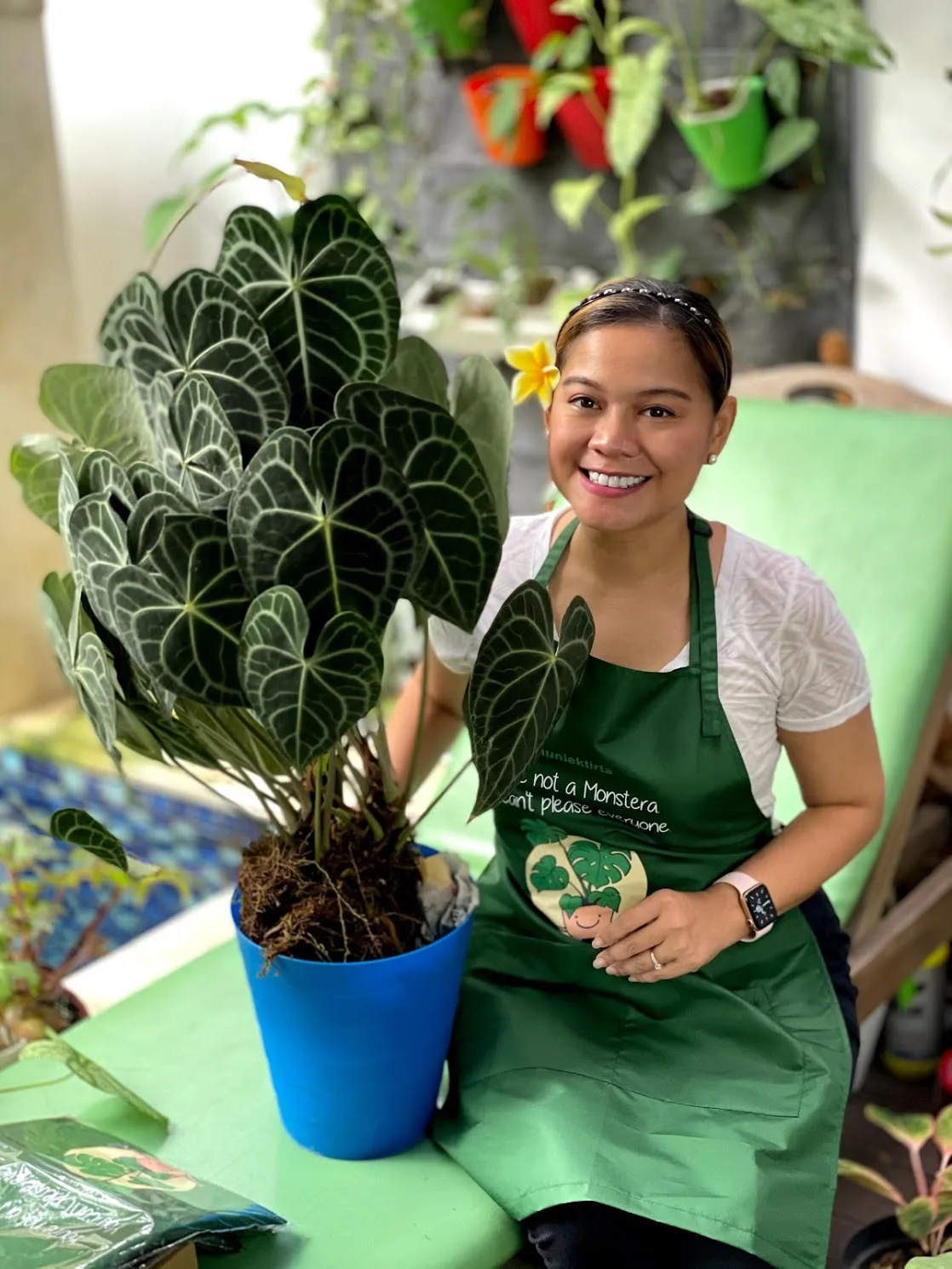 A person smiling next to a potted plant
Description automatically generated with low confidence